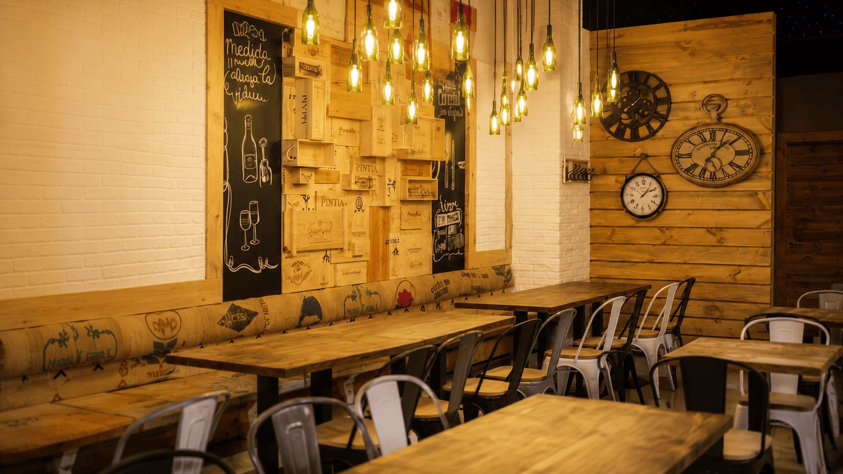 Comedor de Donde Dani con mesas de madera, bombillas colgantes y pizarra rotulada a mano